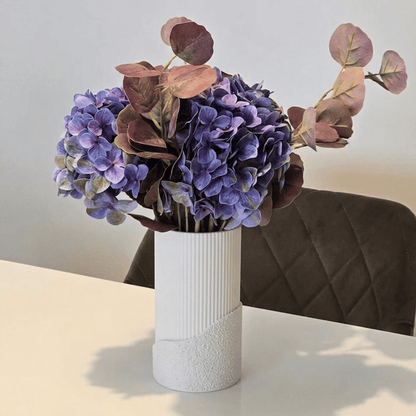 Vaza decorativă Fluora albă, cu buchet de flori uscate, pe masă într-un living luminos